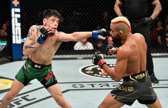 Brandon Moreno of Mexico punches Deiveson Figueiredo of Brazil in their UFC flyweight championship fight during the UFC 263 event at Gila River Arena on June 12, 2021 in Glendale, Arizona. (Photo by Jeff Bottari/Zuffa LLC)