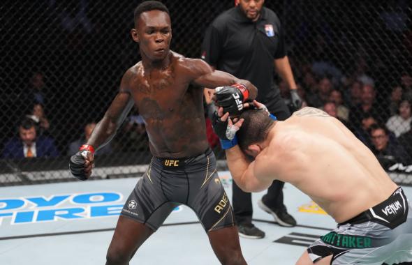 Israel Adesanya of Nigeria punches Robert Whittaker of Australia in their UFC middleweight championship fight during the UFC 271 event at Toyota Center on February 12, 2022 in Houston, Texas. (Photo by Josh Hedges/Zuffa LLC)