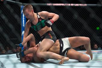 LAS VEGAS, NEVADA - DECEMBER 10:  (Top) Rose Namajunas punches Paige VanZant in their women's strawweight bout during the UFC Fight Night event at The Chelsea at the Cosmopolitan of Las Vegas on December 10, 2015 in Las Vegas, Nevada.  (Photo by Brandon Magnus/Zuffa LLC via Getty Images)