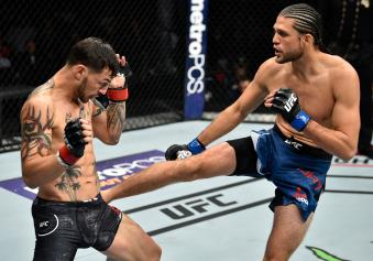 FRESNO, CA - DECEMBER 09:  (R-L) Brian Ortega kicks in their featherweight bout during the UFC Fight Night event inside Save Mart Center on December 9, 2017 in Fresno, California. (Photo by Jeff Bottari/Zuffa LLC via Getty Images)